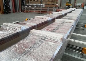 Steel sheet bundles packaged by orbital wrapper with wooden blocks feeding