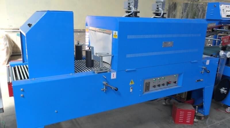 Shrink wrap machine with side pressing rollers